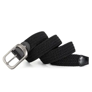 Close-up detail of a black woven elastic belt with a sleek metal pin buckle and leather ends.