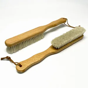 Vue détaillée de la longue brosse en bois à poils de crin blancs pour chaussures et manteaux.