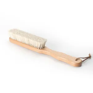 Brosse de nettoyage à long manche en bois avec poils blancs et lanière en cuir pour chaussures.