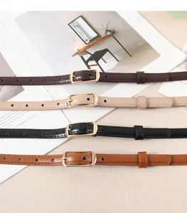 Detailed view of thin leather belt with gold metal buckle, elegant and minimalist design.