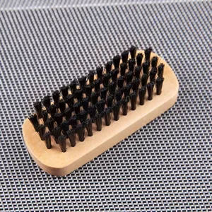 Wooden cleaning brush detail, wood handle with dense black bristles for footwear and clothes.