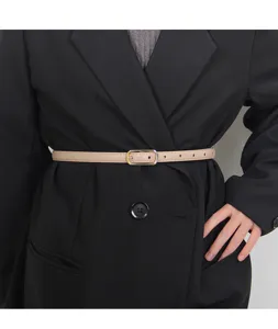 Close-up detail shot of women's thin beige leather belt worn with a stylish black blazer.