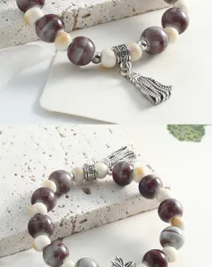 Close-up detail showing intricate ceramic beads, vintage metal spacer charms and delicate tassel.
