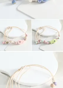 Nahaufnahme des handgefertigten Keramikfisch-Armbands mit bunten Perlen und verstellbarer Kordel.