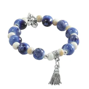 Jingdezhen kiln-transformed ceramic beaded bracelet with chic tassel charm and floral accent.