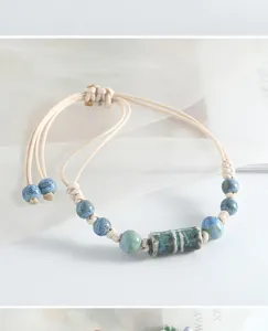 Vue détaillée du bracelet tressé en perles de céramique de style chinois en tons bleus.