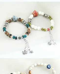 Primo piano dei dettagli di bracciali in perline di ceramica fatti a mano con ciondoli.