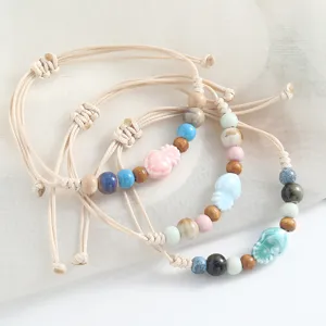 Close-up detail of handmade ceramic beaded bracelet with wooden beads in literary style.