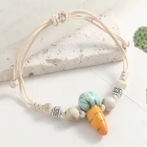 Ceramic carrot beaded bracelet detail shot, fresh style woven cord jewelry with spacer beads.