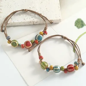 Fresh literary ceramic bead bracelet with handmade braided cord, elegant artistic details view.