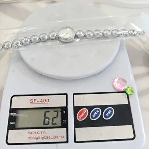 Detaillierte Ansicht der silbernen Perlenarmbanduhr auf einer digitalen Waage mit einem Gewicht von 62g.