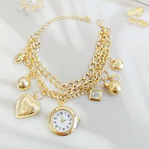 Goldenes mehrlagiges Charm-Armbanduhr mit Herz- und Diamantanhängern, elegante Detailansicht.