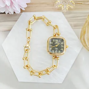 Detailed close-up of luxurious gold square watch with stylish paperclip link bracelet design.