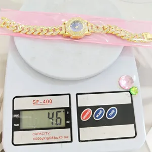 Vista dettagliata dell'orologio da donna a catena cubana dorata con strass su bilancia.