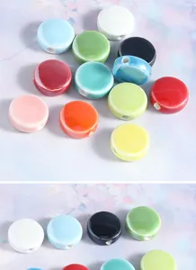 Close up view of colorful flat ceramic beads with glossy finish, perfect for DIY jewelry making.
