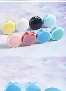 Close-up detail of colorful ceramic flat round beads with hole, ideal for DIY handmade bracelets.