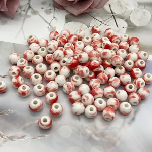 Detailed shot of red and white splatter ceramic loose beads, perfect for DIY jewelry making.