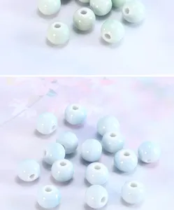 Ceramic loose beads detail view, smooth glazed round charm with center hole for DIY crafting.