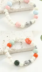 Close-up of ceramic beaded bracelet with cute fish charms and colorful beads, detail view.
