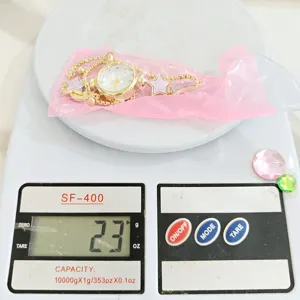 Detailed view of fashionable gold women watch bracelet with star moon charms, 23g weight.