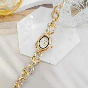 Montre quartz femme dorée irrégulière chic avec bracelet chaîne chunky et strass brillants.