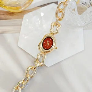 Vue de détail d'une montre femme tendance en strass irréguliers avec bracelet chaîne or.