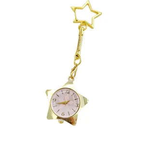 Gold star pocket watch detail, featuring a charming star-shaped charm and delicate floral dial design.