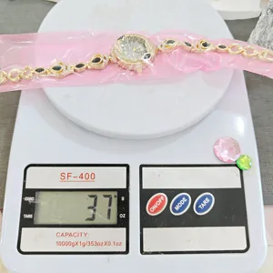 Detail view of women luxury rhinestone koi design watch placed on digital scale.