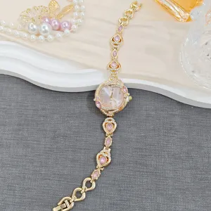 Women gold bracelet watch with pink crystal teardrops and white dial quartz luxury timepiece.