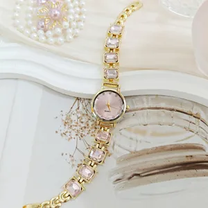 Elegante reloj de pulsera de cuarzo para mujer con correa dorada y cristales rosas.