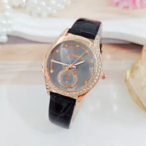 Detailaufnahme Damenuhr mit Strass-Lünette, grauem Zifferblatt und schwarzem Lederarmband.
