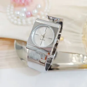 Silver cuff watch close up, elegant square case quartz timepiece with metallic strap.
