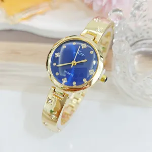 Detailopname van gouden quartz dameshorloge met blauwe wijzerplaat en strass sterren.