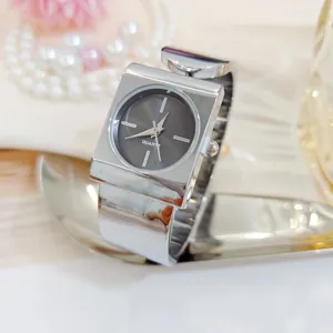 Silver square quartz watch for women, stylish bracelet wristwatch with dark dial detail.