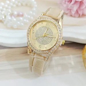 Gouden dames kwartshorloge met strass steentjes en beige band gedetailleerd overzicht parels.