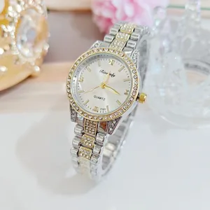 Gros plan montre quartz femme, ton argent or, lunette strass et bracelet métal scintillant.
