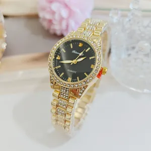 Detail gros plan de montre quartz strass doree femme avec un cadran noir elegant.