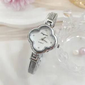 Dettaglio orologio da donna quadrante trifoglio con strass luminosi e cinturino in metallo fine.