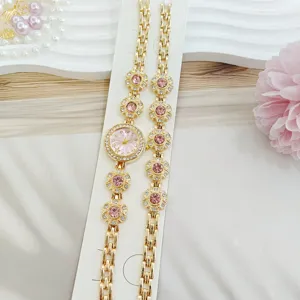 Vue détaillée de la montre pour femme dorée et du set de bijoux bracelet en cristal rose.