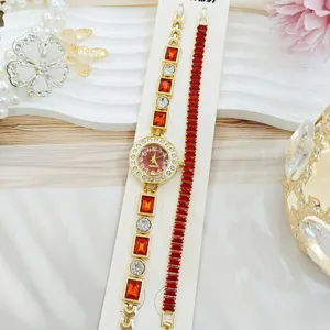 Montre quartz pour femme ton or et bracelet de bijoux en strass cristal rouge vue de détail.