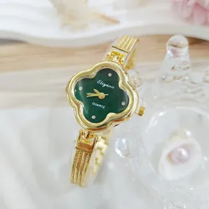 Orologio al quarzo quadrifoglio verde dettaglio, elegante bracciale oro da donna.