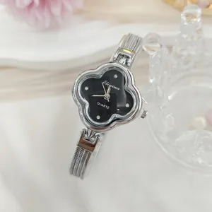 Primo piano dettaglio di orologio donna quarzo con quadrante quadrifoglio e cinturino maglia.