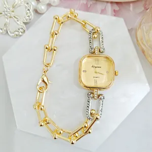 Detailed view of luxury square rhinestone gold chain quartz women's watch, elegant fashion.