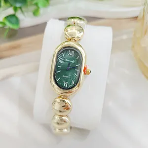 Elegante Retro Quarz-Armbanduhr mit ovalem grünem Zifferblatt und goldenem Perlenarmband.
