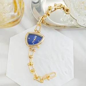 Luxe gouden kettinghorloge voor dames met unieke onregelmatige blauwe wijzerplaat detail.