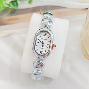 Elegante Quarzuhr mit ovalem Zifferblatt und einzigartigem silbernem Perlenarmband Detail.