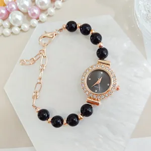 Women's quartz watch with black beaded bracelet, rose gold chain and rhinestone dial.