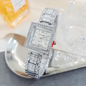 Primer plano del detalle del reloj de cuarzo cuadrado con estrás, brazalete de metal con diamantes.