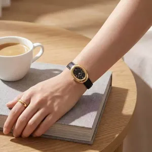 Primo piano dettagliato di elegante orologio da donna al quarzo con cassa ovale dorata e cinturino.