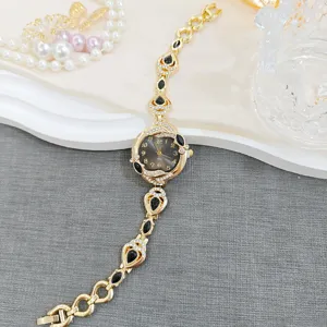 Vintage gold quartz watch for women, black teardrop crystal bracelet design, luxury vintage style.